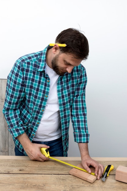 Man using ruler and wood carpentry workshop concept