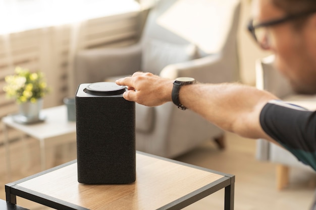 Free photo man using a smart speaker while working