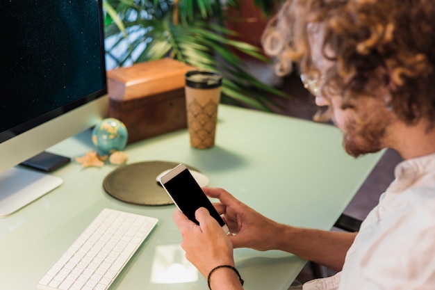 Man using smartphone at desk