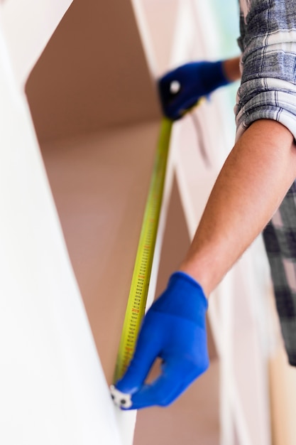 Man using tape measure on a wall