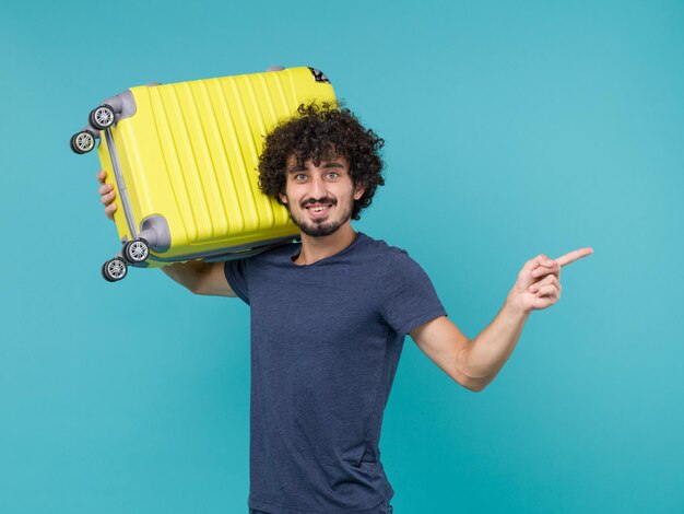 man in vacation holding yellow bag on a blue