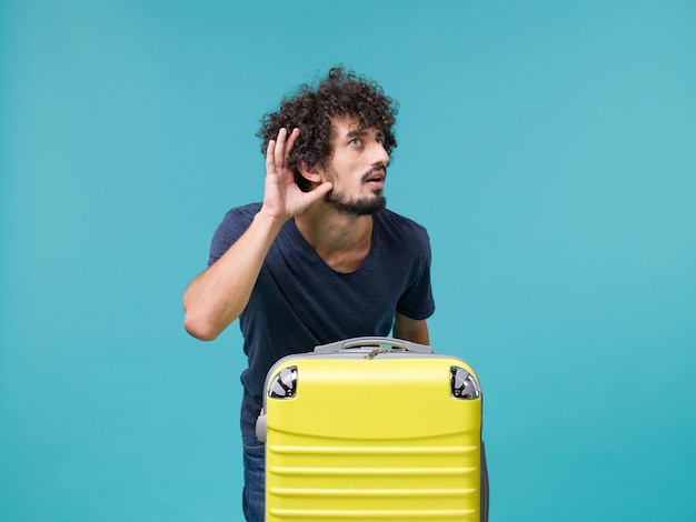 man in vacation with yellow suitcase on blue