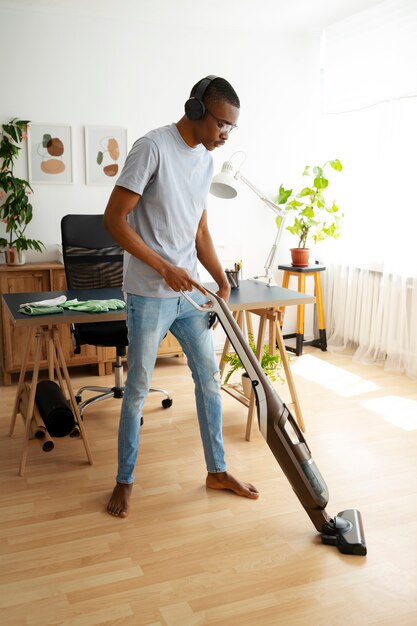 Man vacuuming floor full shot