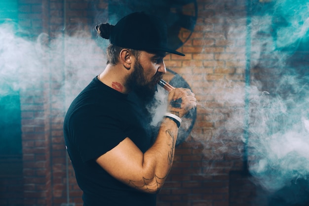 Free photo man vaping an electronic cigarette