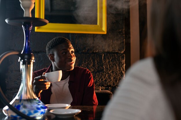 Man vaping from a hookah in a bar