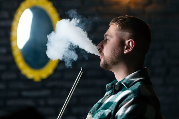 Man vaping from a hookah in a bar