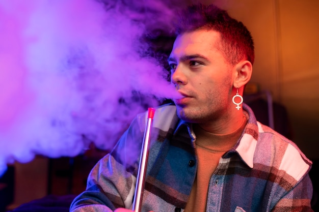 Free Photo man vaping from a hookah indoors