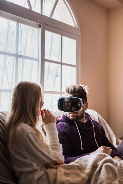 Man in Vr glasses looking at girlfriend