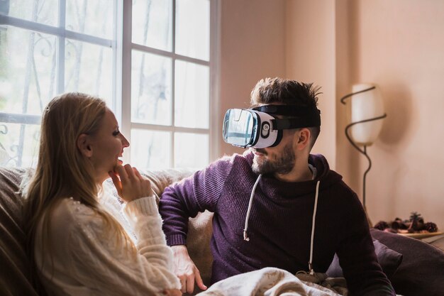 Man in VR headset looking at laughing woman