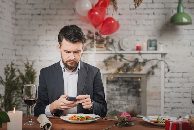 Man waiting for date checking phone