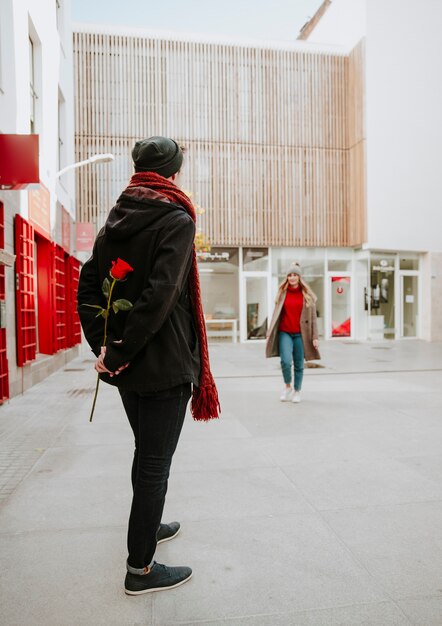 Man waiting woman for giving red rose