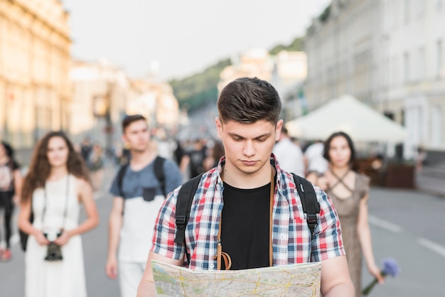 Free photo man walking on street with map