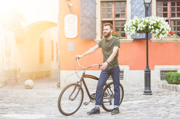 Man walking with his bicycle on stone pavement