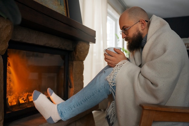 Man warming at fireplace during energy crisis