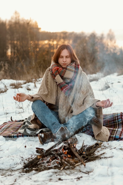 Man warming up next to a campfire in winter