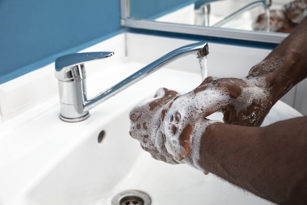 Man washing hands carefully in bathroom close up prevention of infection 