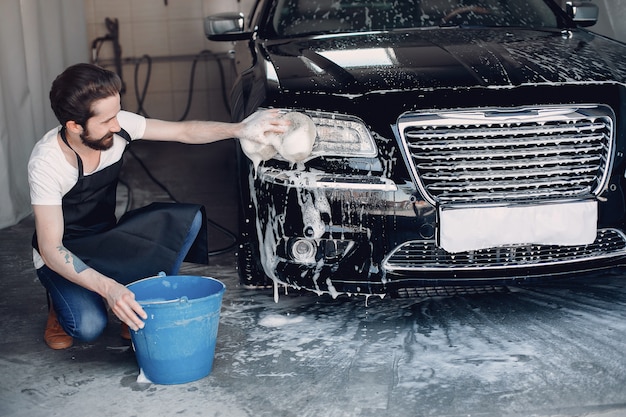 Man washing his car in a garage