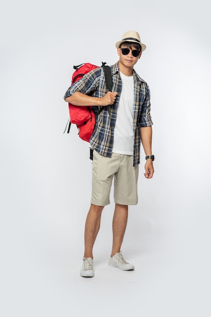 Free Photo a man wearing glasses goes out to travel, wear a hat and carry a backpack