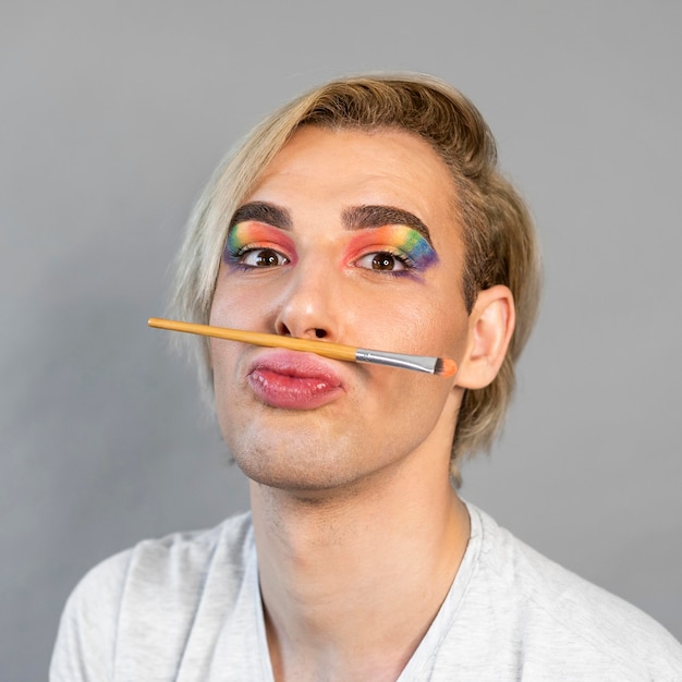 Free photo man wearing make-up rainbow cosmetics