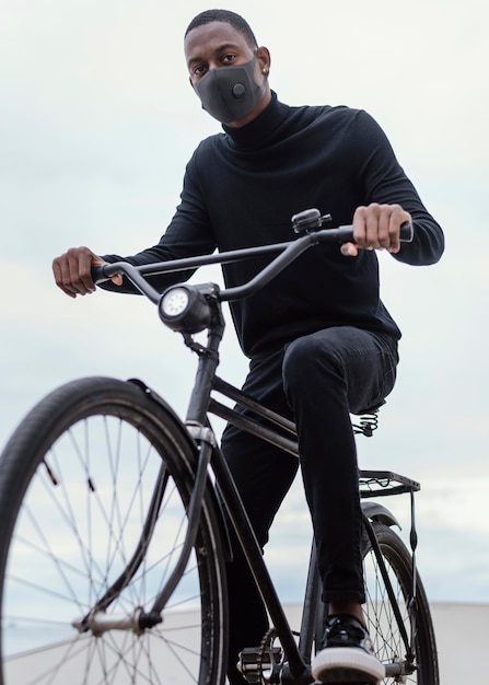 Man wearing mask riding his bike in the city