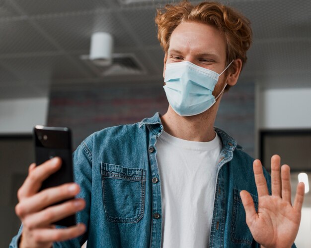 Man wearing medical mask and looking at the phone