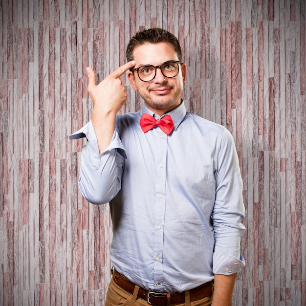 Free photo man wearing a red bow tie. doing a gun gesture.