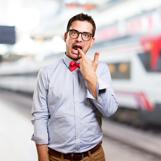 Man wearing a red bow tie. Doing a gun gesture.