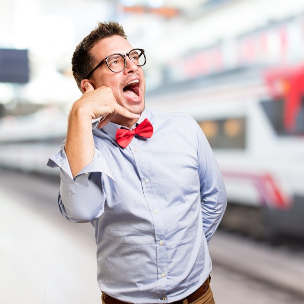 Man wearing a red bow tie. Doing a phone gesture.