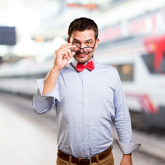 Man wearing a red bow tie. Looking over glasses.