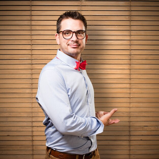 Man wearing a red bow tie. Showing something.