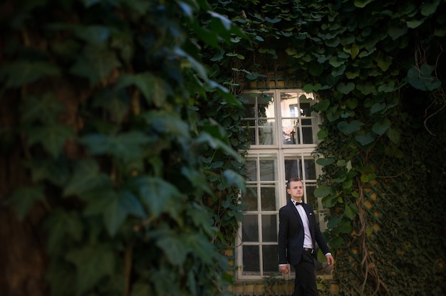 "Man wearing suit walking by window"