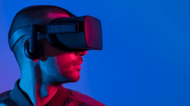 Free photo man wearing vr glasses with blue light