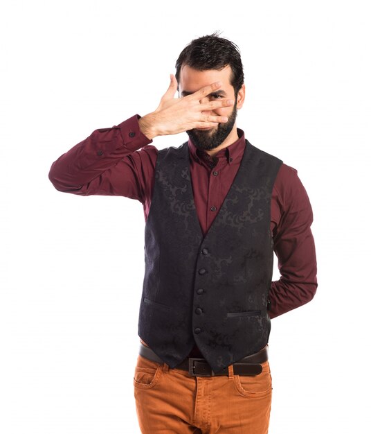 Man wearing waistcoat covering his eyes