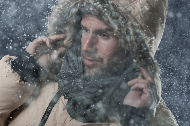 Free Photo man wearing a winter jacket while it's snowing