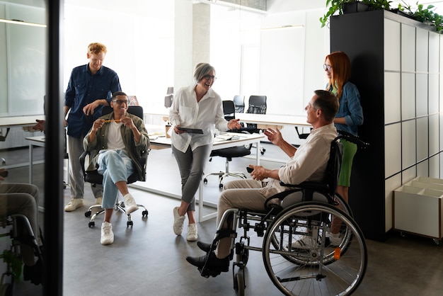 Free Photo man in a wheelchair having an inclusive office job