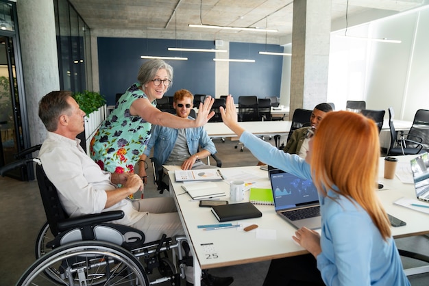 Free photo man in a wheelchair having an office job