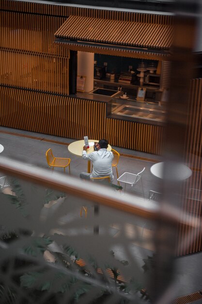 Man in white long sleeve shirt sitting on chair in cafe