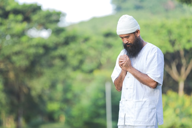 Man in white outfit meditating in nature