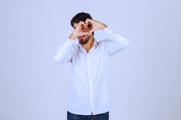 Man in white shirt blowing love to his fans.