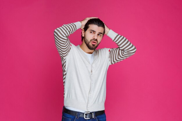 Man in white shirt has headache and holding his head. 