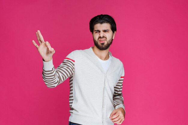 Man in white shirt making ok or perfection hand sign. 