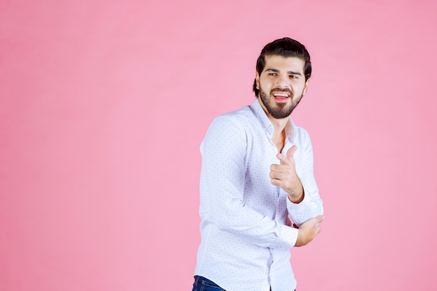 Man in a white shirt noticing and pointing at the person ahead.