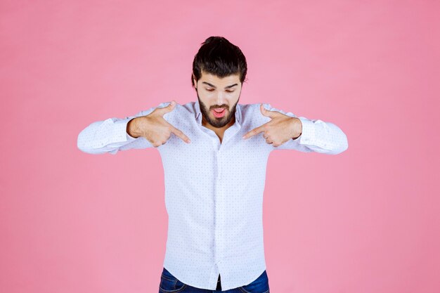 Man in a white shirt pointing at himself.