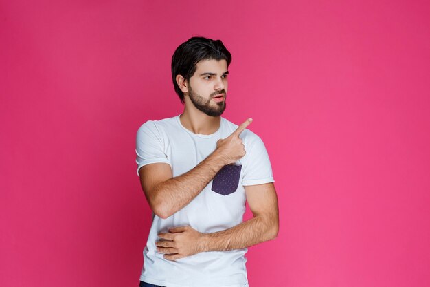 Man in white shirt pointing and presenting something in the right side.