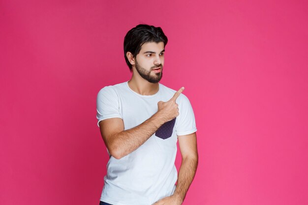 Man in white shirt pointing and presenting something in the right side.