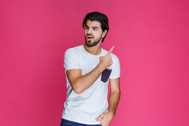 Man in white shirt showing something above.