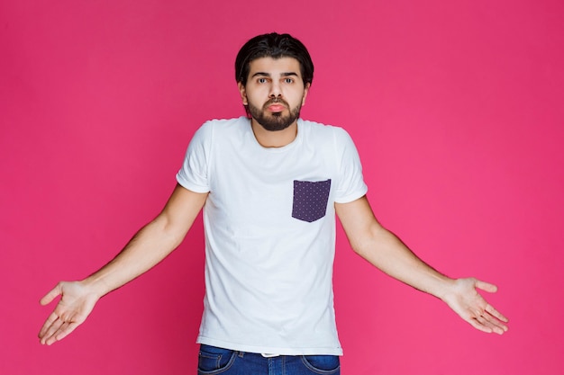 Free Photo man in white shirt showing that he has no idea about the topic. 