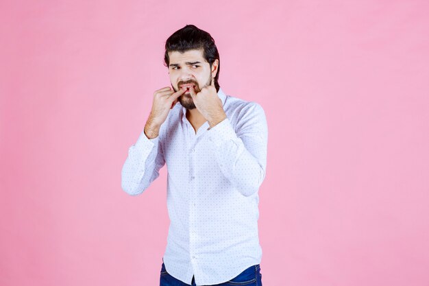 Man in a white shirt whisting with fingers.