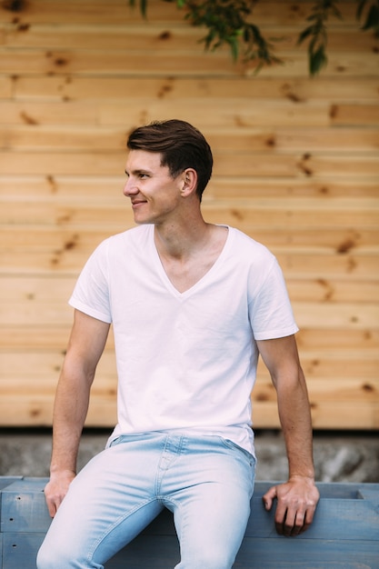 Free Photo man in white t-shirt sitting and smiling