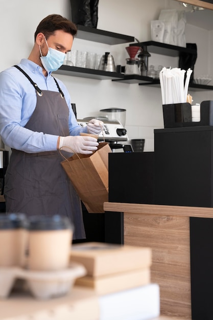 Man with apron preparing food for takeaway